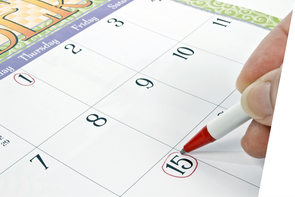 Stock photo of a person circling a date on their calendar.